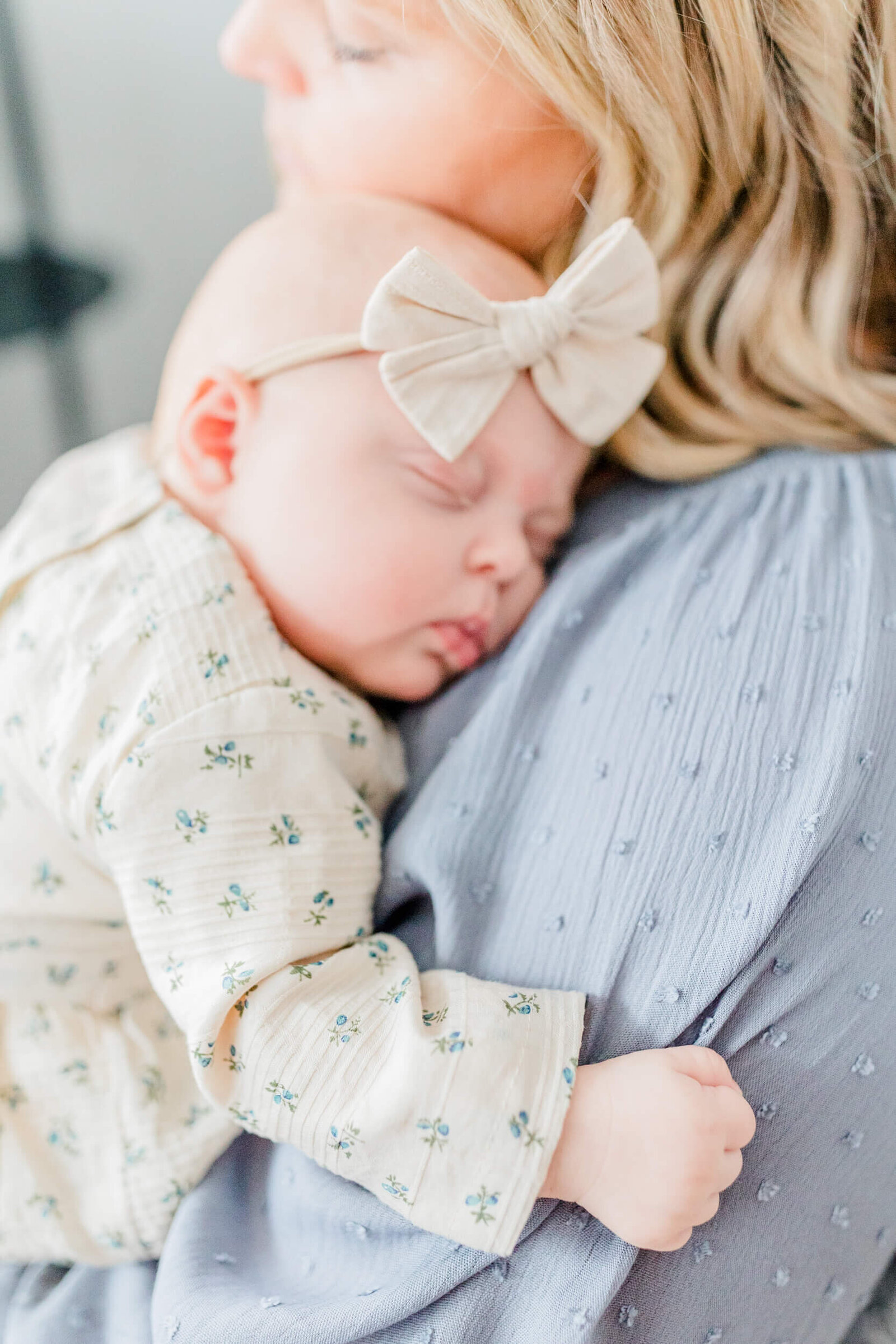 baby's hand holds on tight to her mama's dress