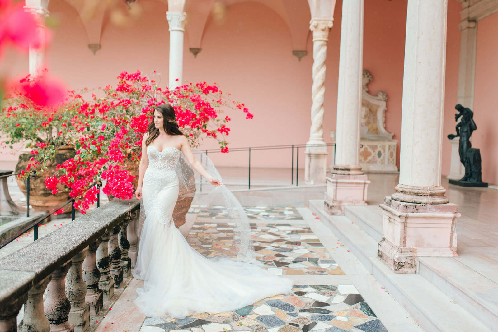 Bride wearing a luxury gown by bougainvillea at John and Mable Ringling Museum of Art in Sarasota