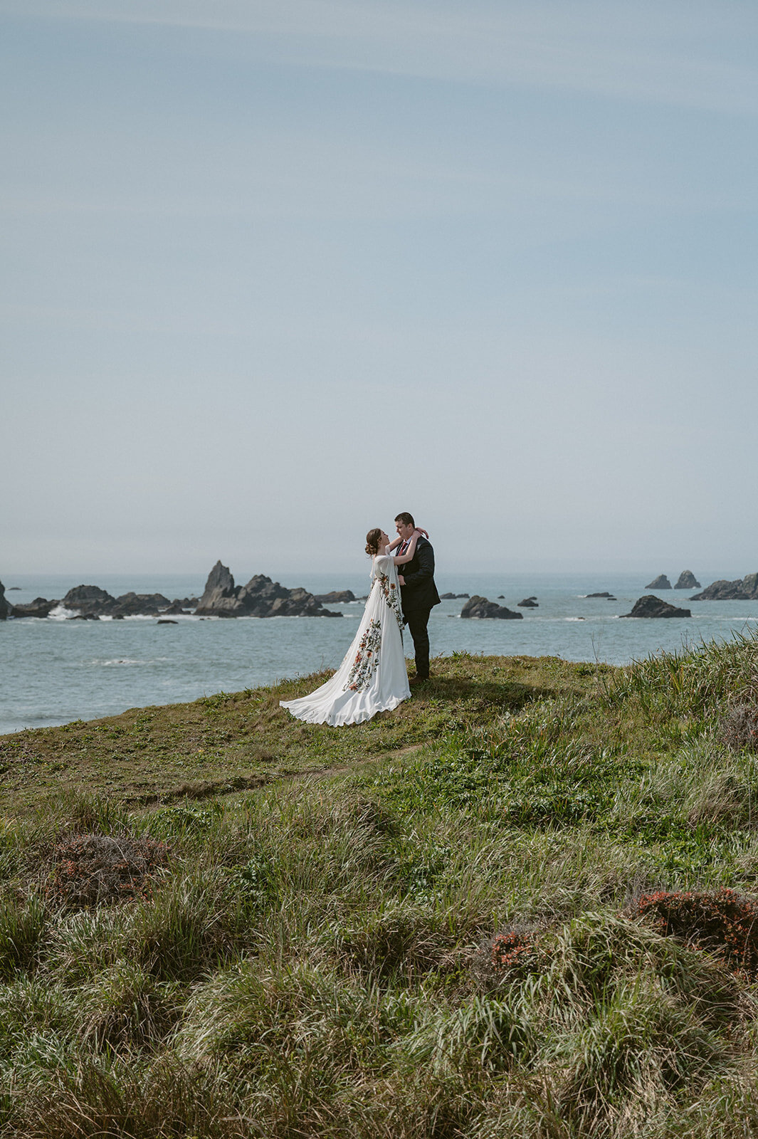 Couple stand on the cliff by the beach