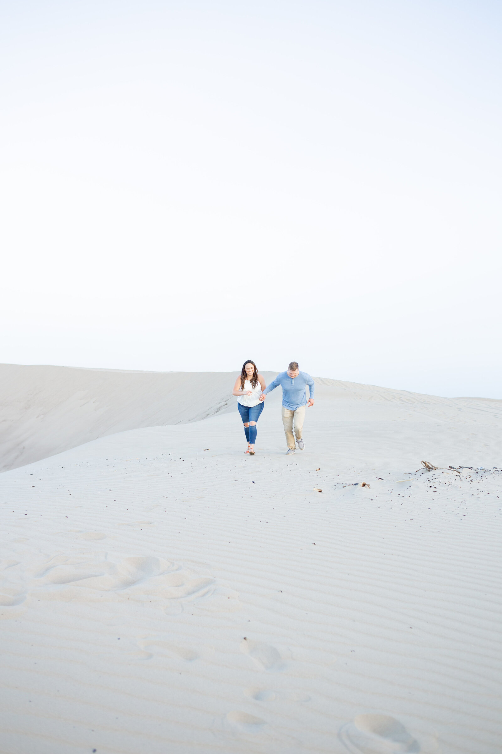 Seattle Wedding Photographer captures couple running on the sand during engagement session