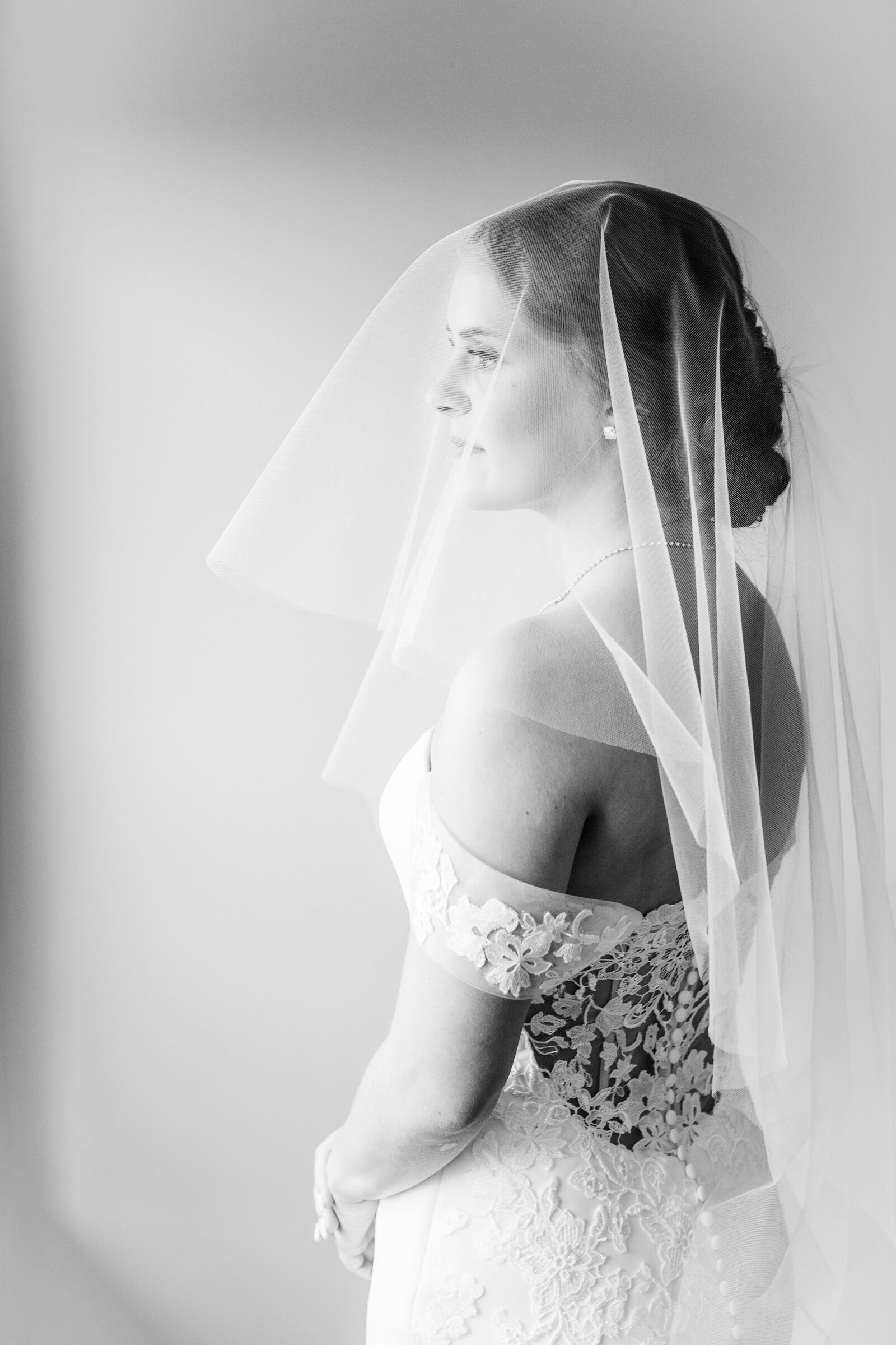 Bride-looking-out-window-under-her-wedding-veil-after-getting-ready