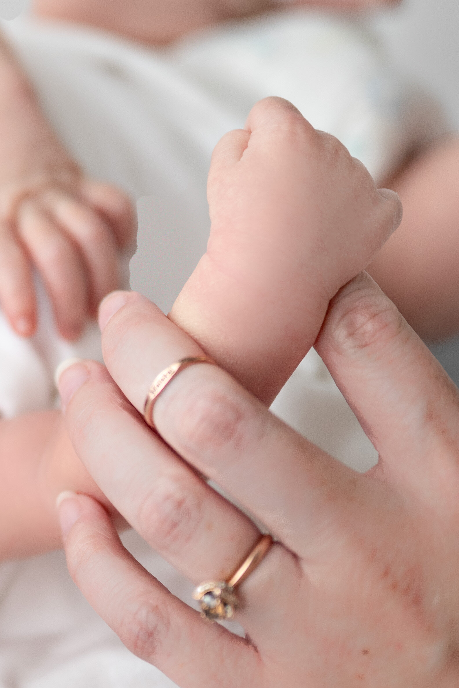 A newborn baby grasping his mother's finger at a photoshoot in Huntsville Alabama