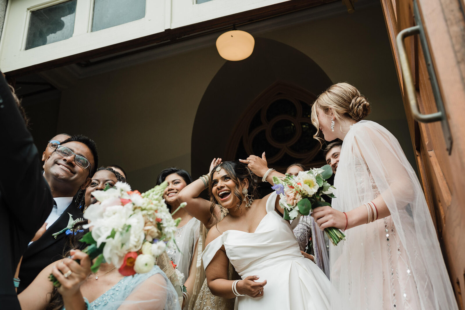Candid moment of bride and wedding guests celebrating after wedding ceremony.