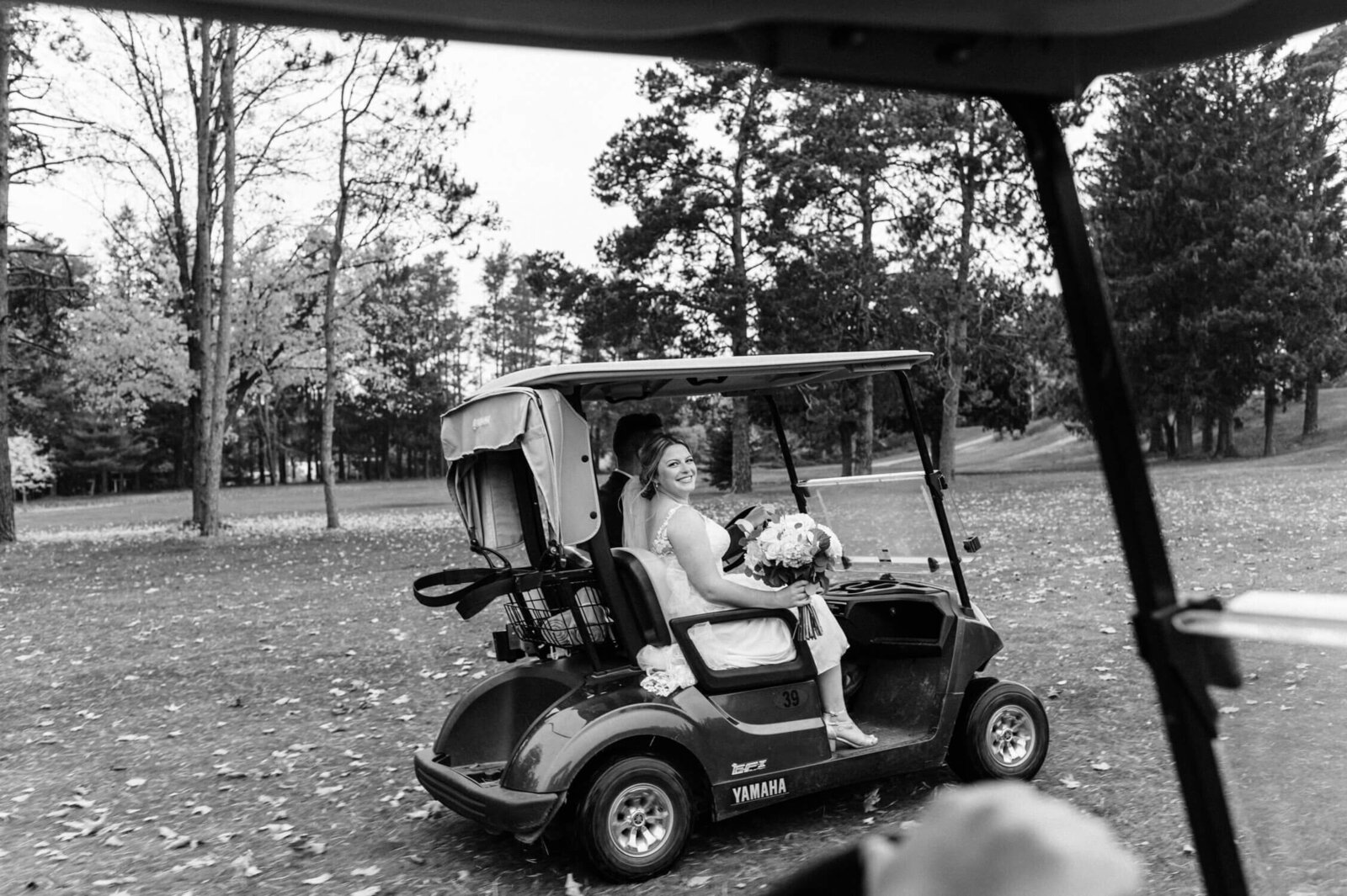 Wedding couple riding gold cart at Nova Scotia wedding.
