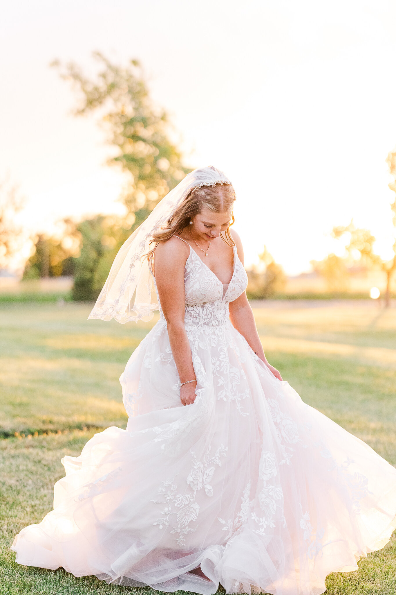 Bride playfully swishing her dress from side to side during golden hour at a Loma wedding at Absolute Prestige