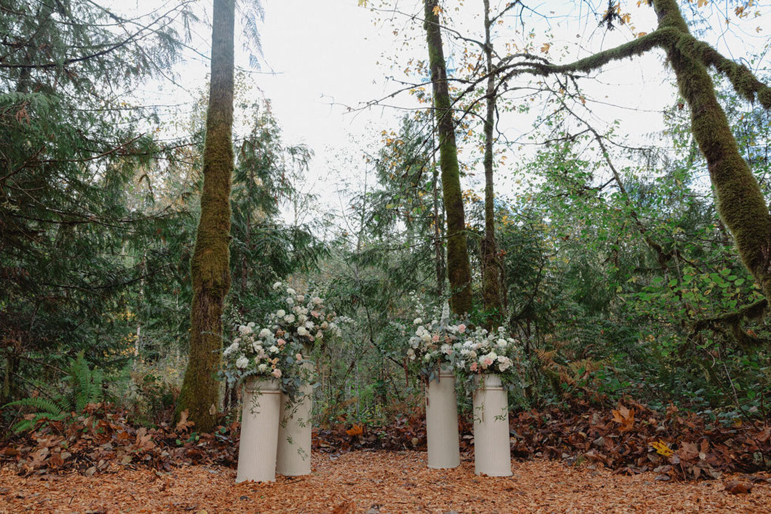 Outdoor wedding altar with floral arrangements in a forest setting