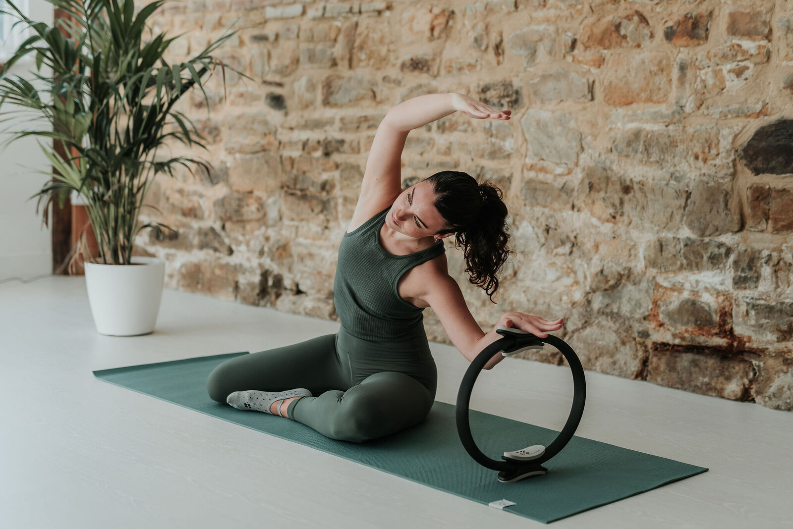 Female pilates instructor demonstrating pilates exercise using a resistance circle