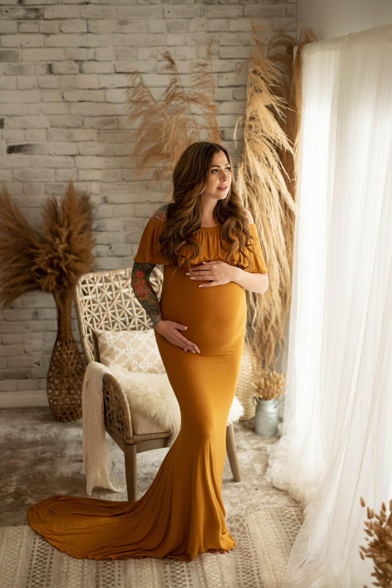 Long haired pregnant woman in mustard colour tulip gown
