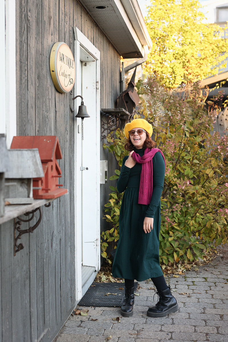 Girl wearing green dress and yellow biretta on the farm in Quebec.