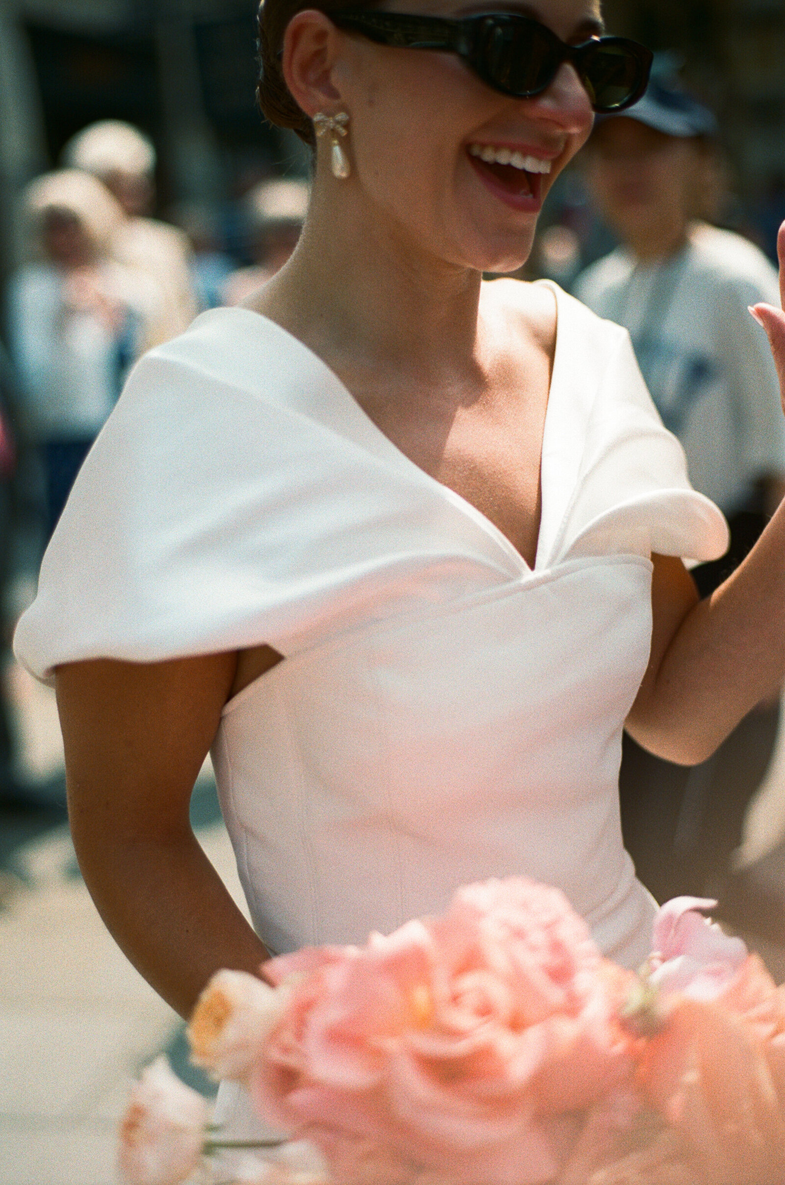 35mm film wedding photo of cool city bride wearing sunglasses in summer in Westminster Abbey wedding holding beautiful peach and pink bridal bouquet
