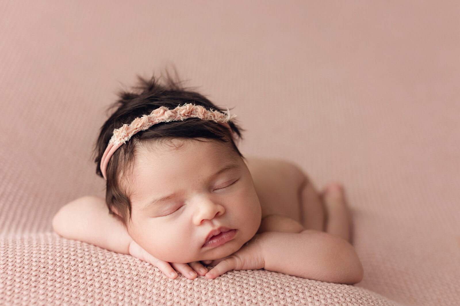 newborn baby girl on pink blanket