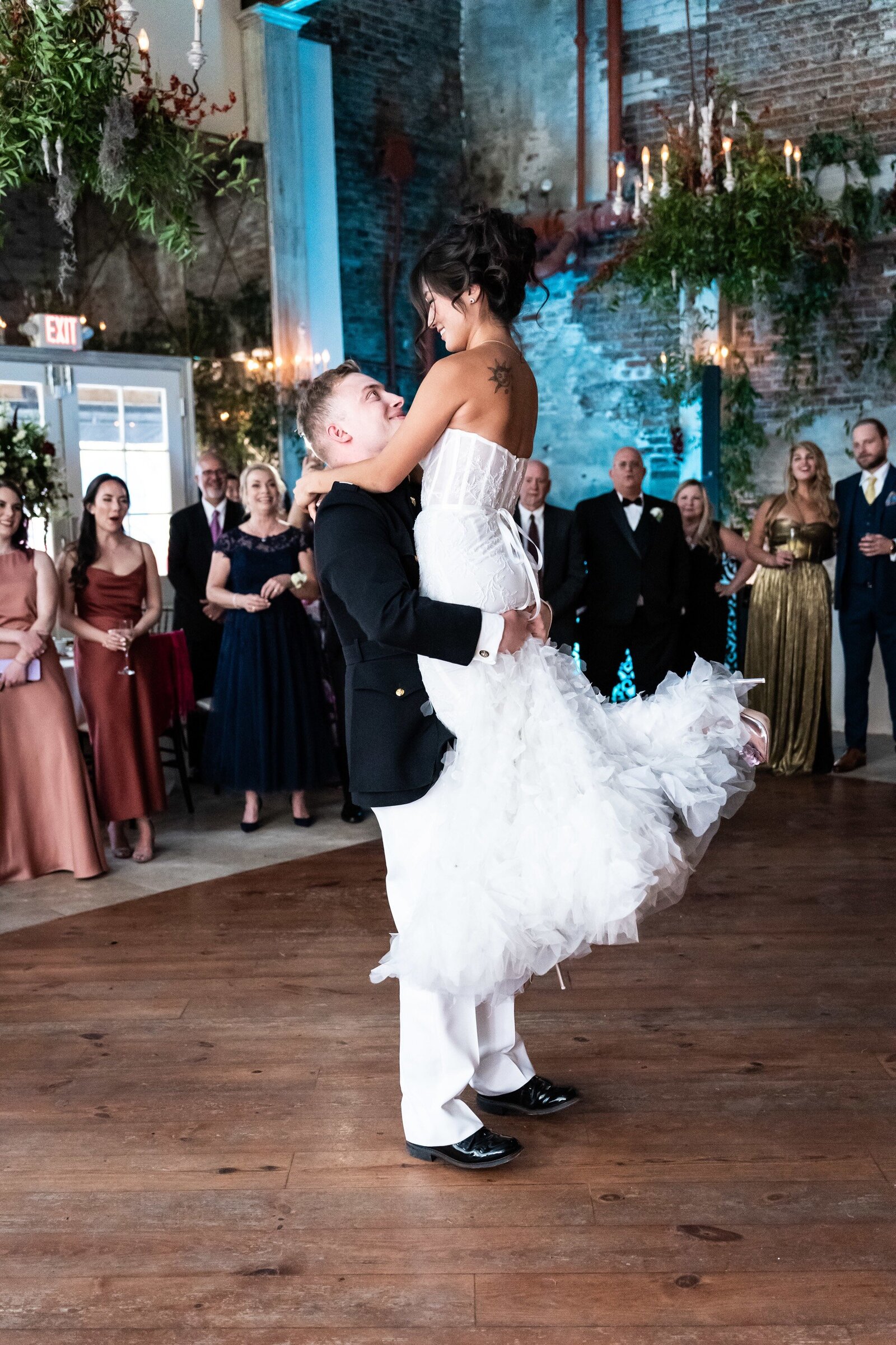 Groom lifts bride at Gallery Venue at Tomas Bistro wedding reception