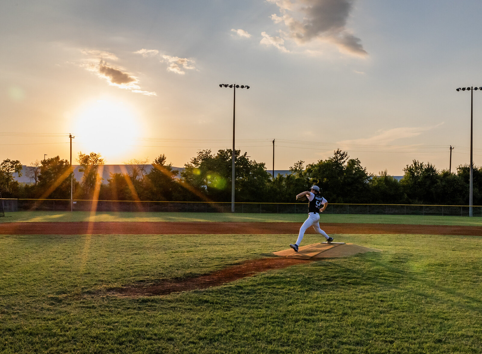 senior pitching with sunset
