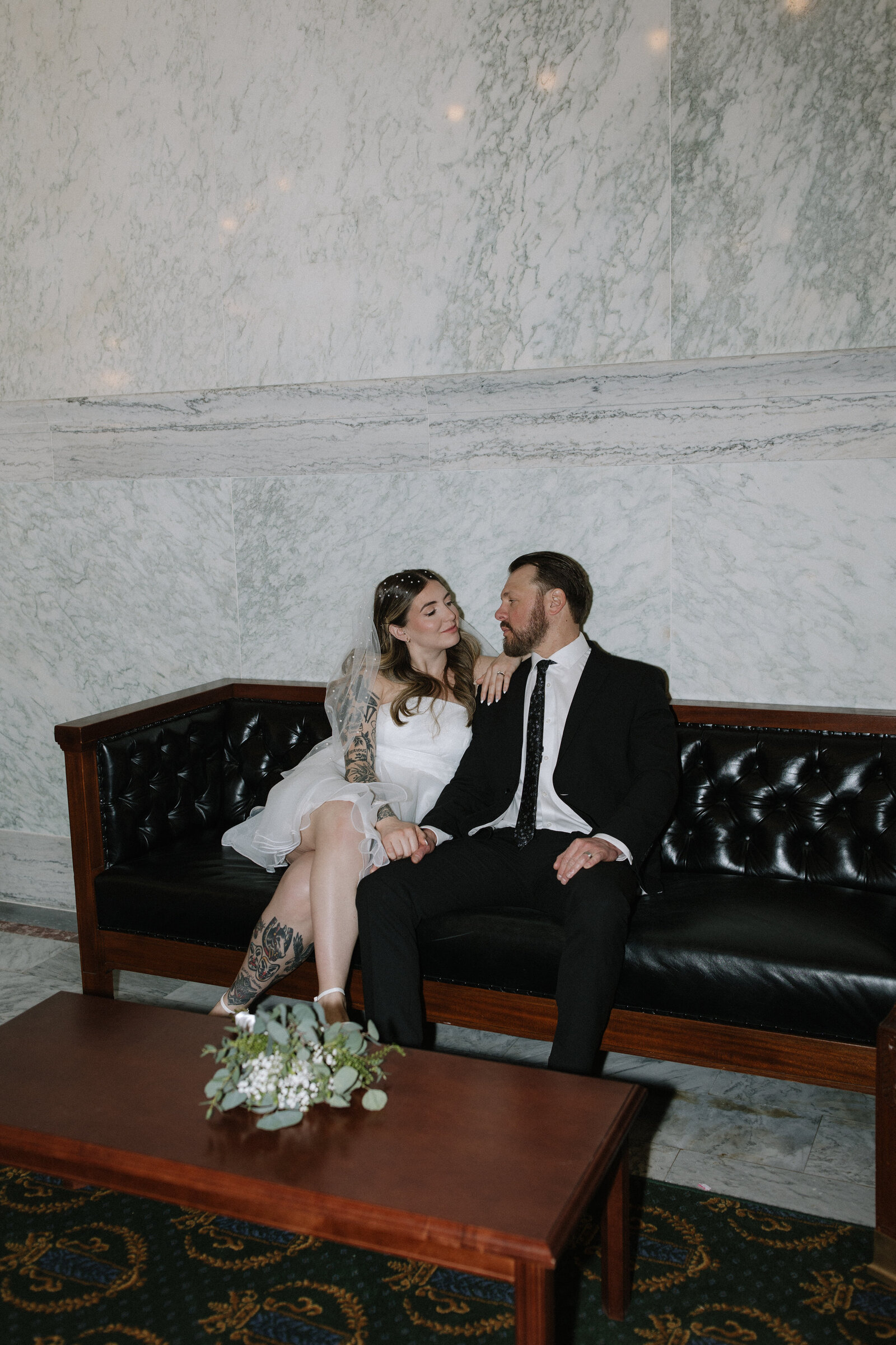 Edgy flash bridal portrait in leather chair inside historic Capitol building