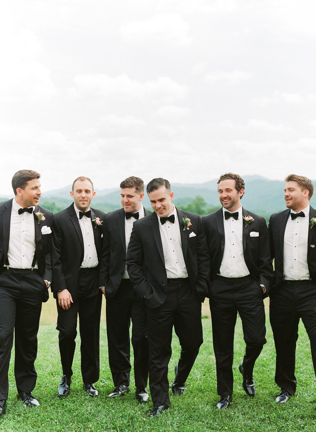 Groom and groomsmen walking laughing