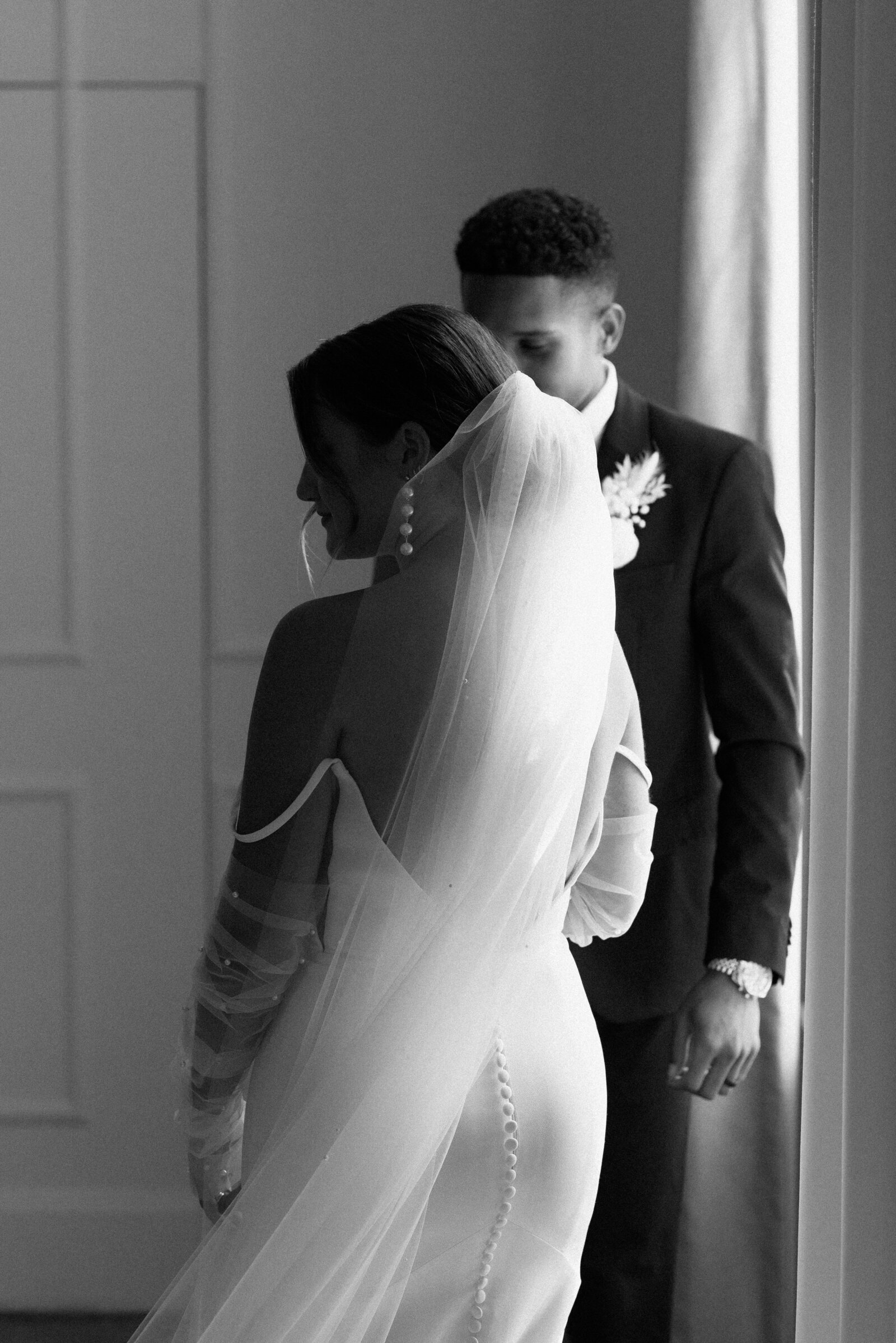 black and white photo of bride and groom looking at the ground