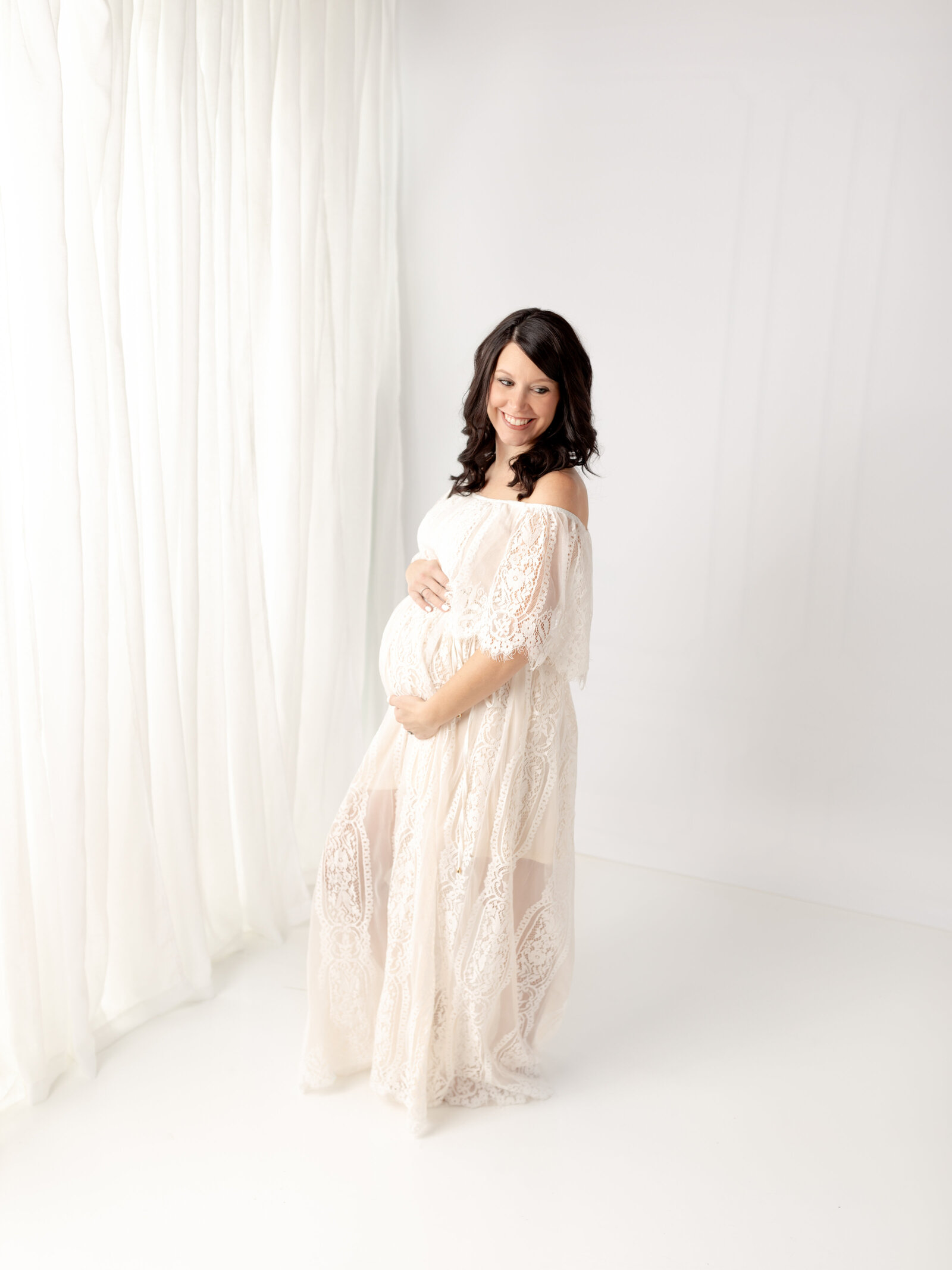 pregnant mother in white lace dress posing for photoshoot cleveland maternity photographer