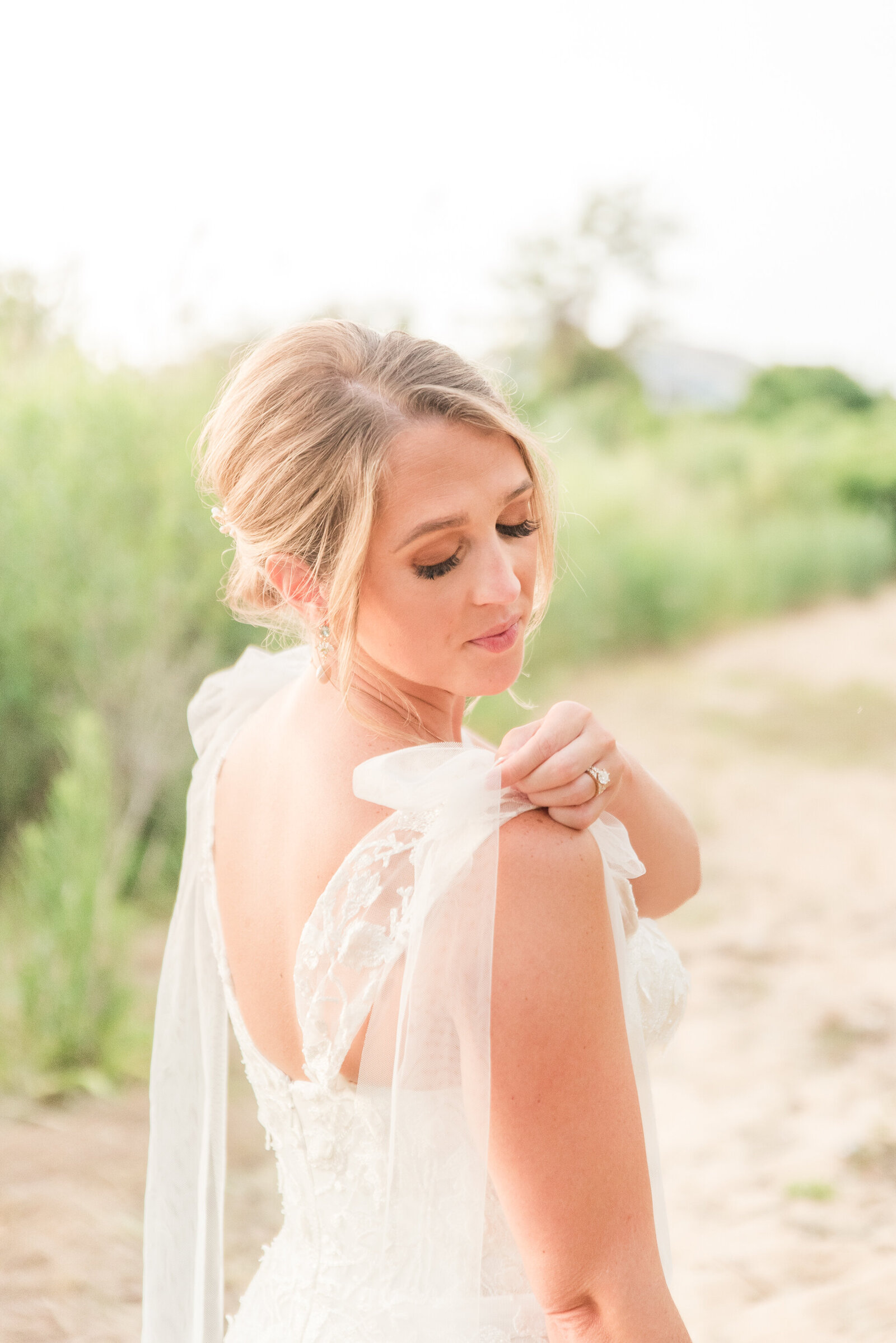 bride adjusting her bow strap  tulle gown