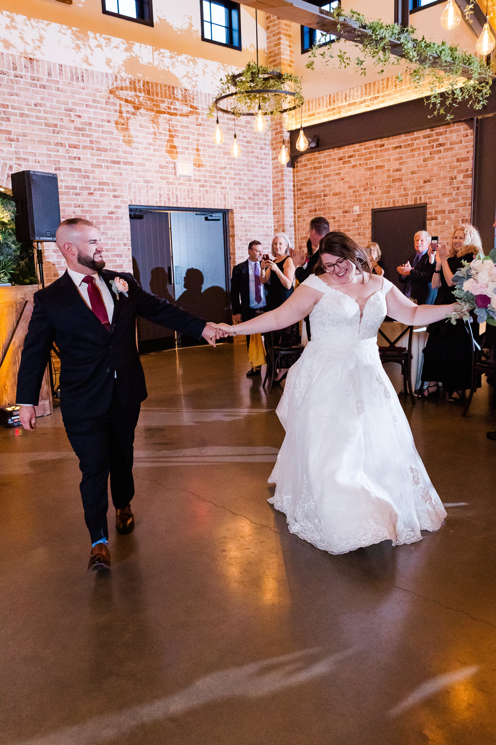 Bride and groom entering their Perona Farms reception smiling and celebrating with guests