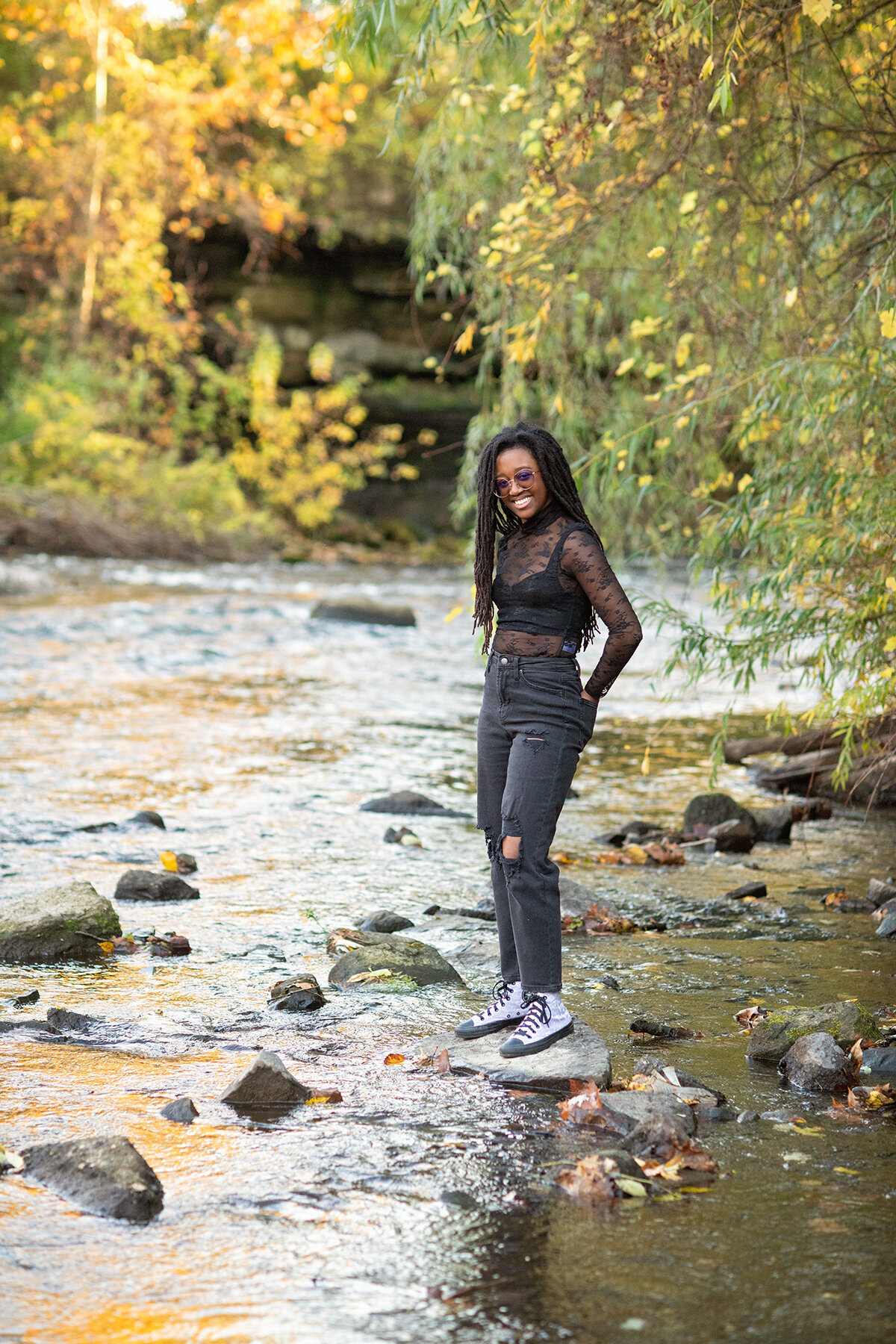 teenage girl stands on rock in the cuyahoga river
