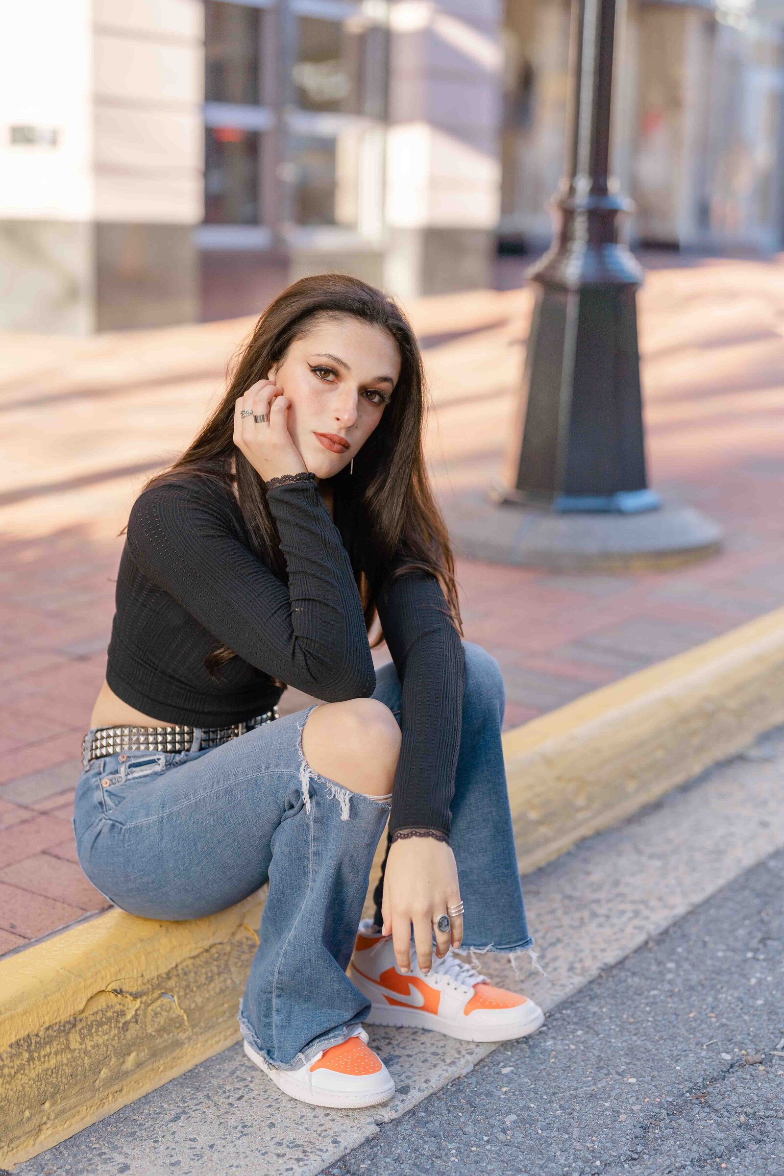 girl sitting on a sidewalk taken by Reston, Virginia senior photographer