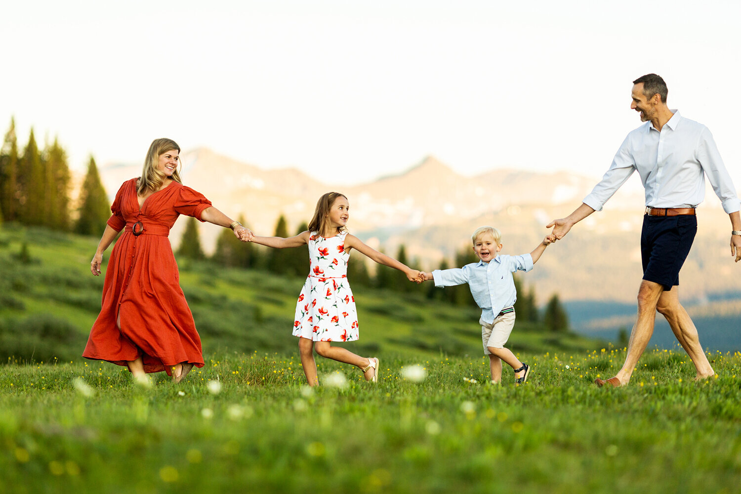 Family Photography, family of 4 walking hand in hand in green field
