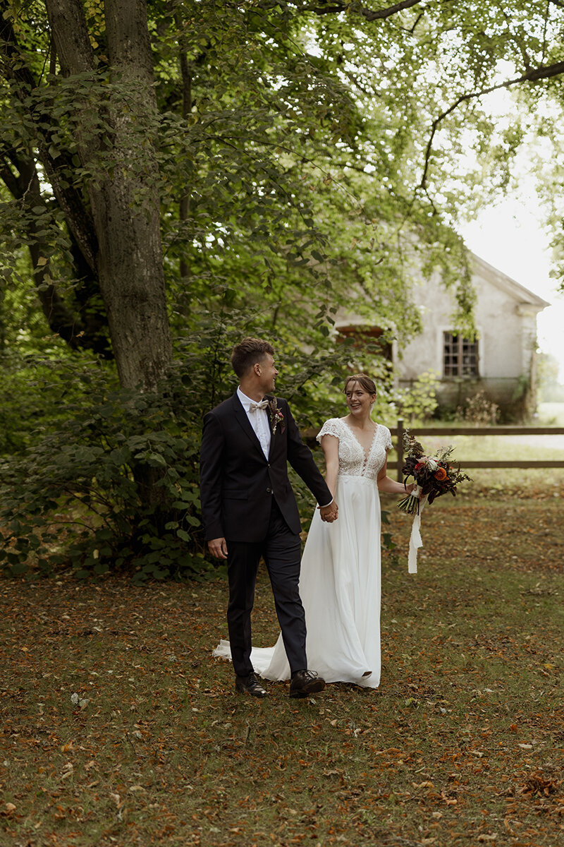 Brudpar går runt i en lövskog