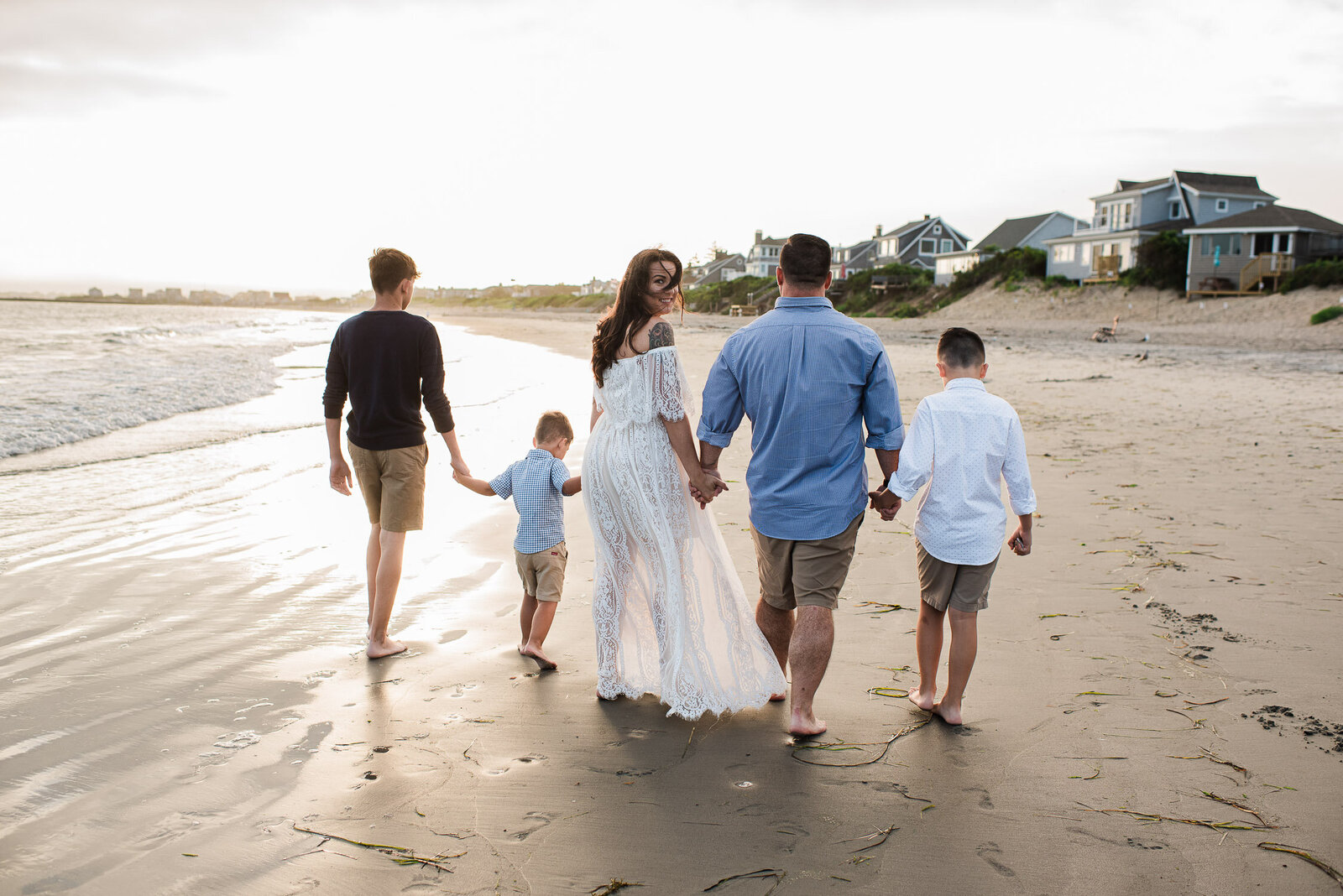 family walking on beach from behind