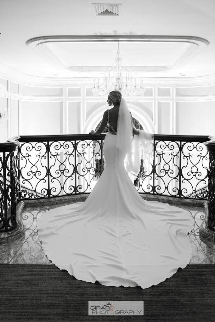 Portrait of bride in her wedding gown, showcasing the back and train