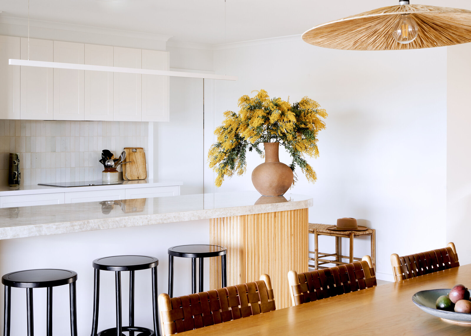 White and timber kitchen stytled with large wattle plant and feature timber
