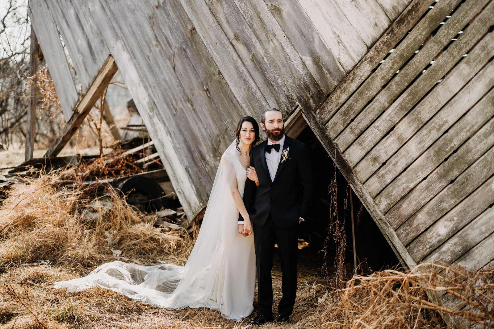 bride veil and groom tux at old barn