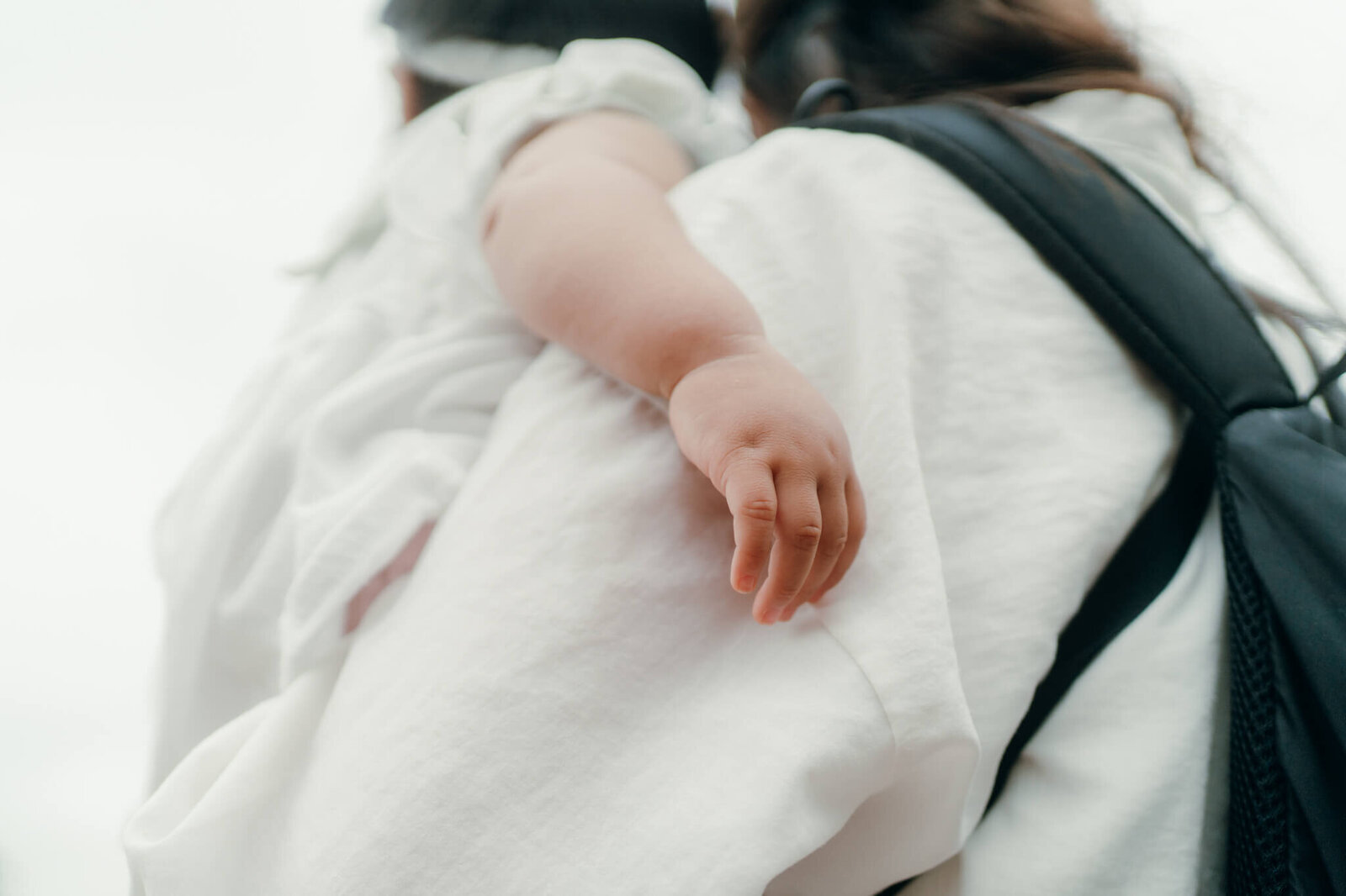 ママに抱かれた赤ちゃんの手のアップ