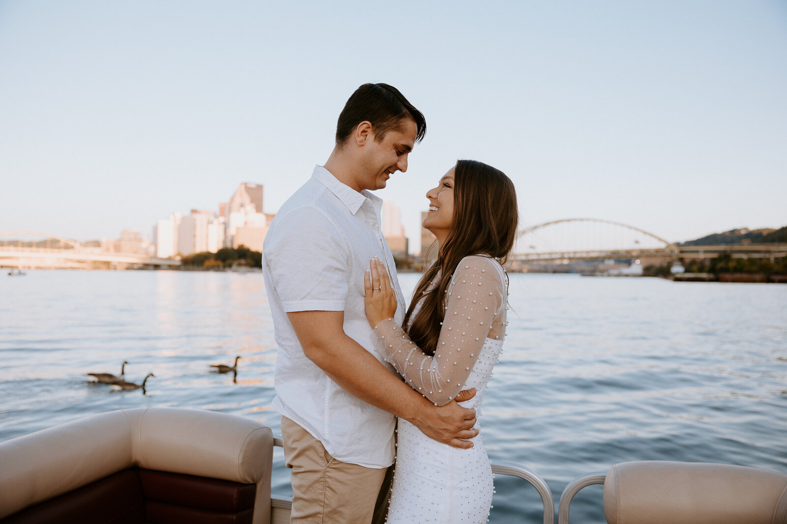 Pittsburgh engagEngaged couple on a boat in the water by Pointe State Park captured by Pittsburgh wedding photographer