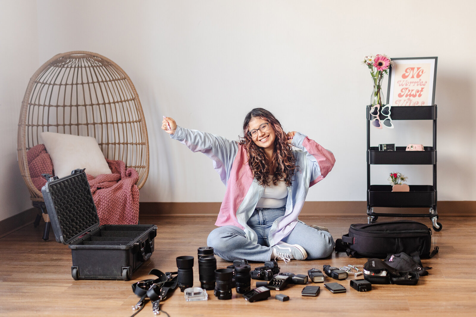 a wedding photographer smiles in front of her gear