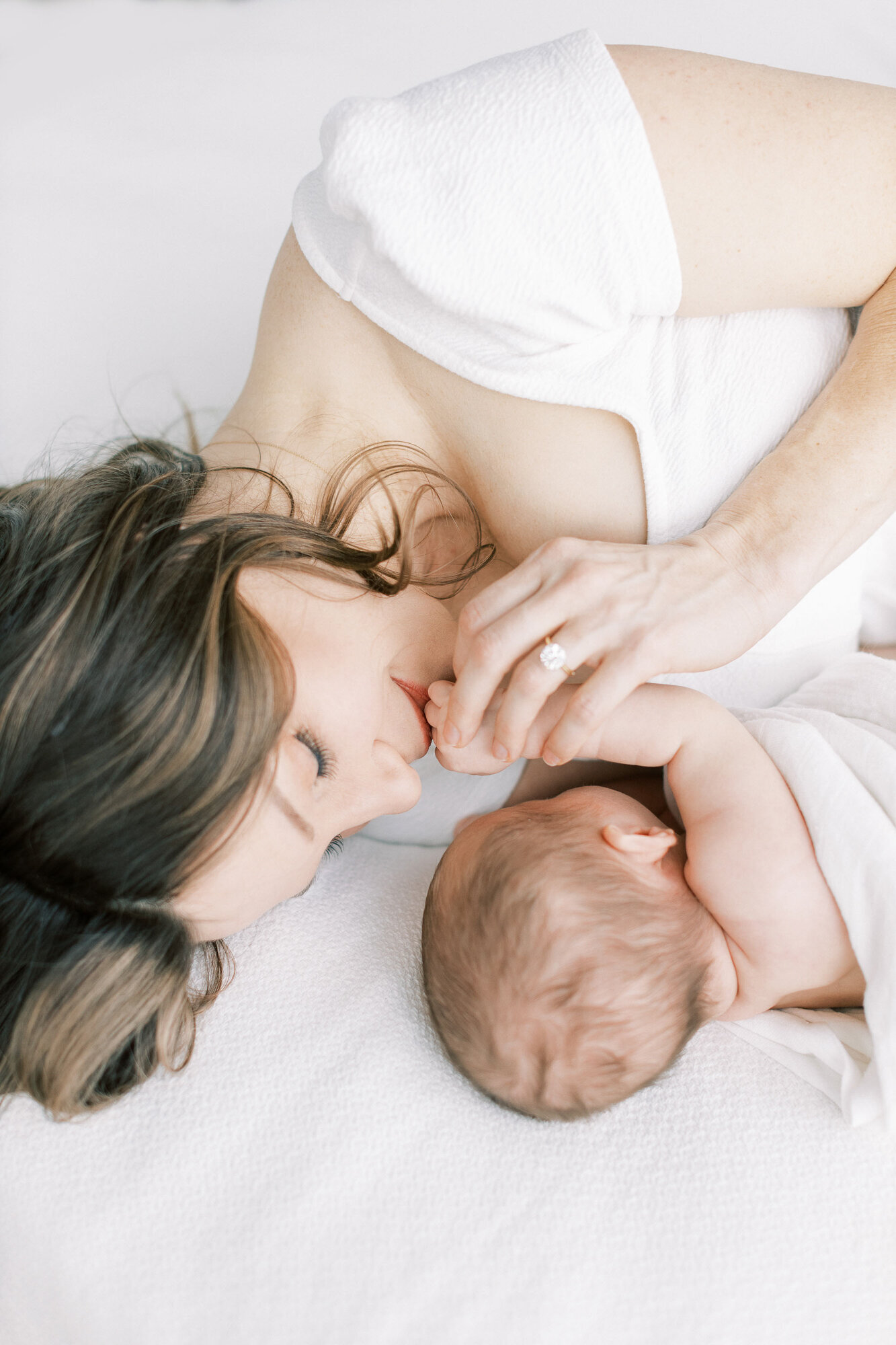 mom-kissing-newborn-hand