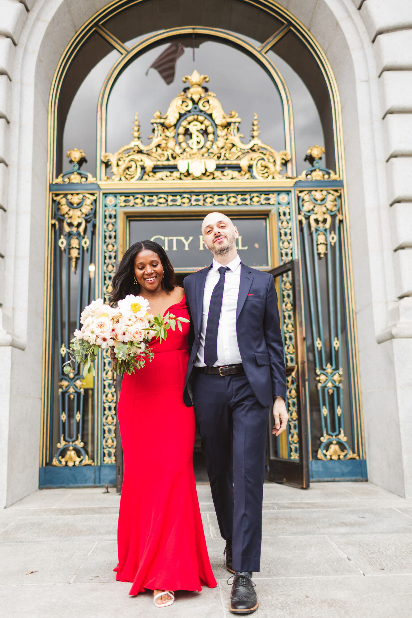 bride in red wedding dress exiting San Francisco City Hall