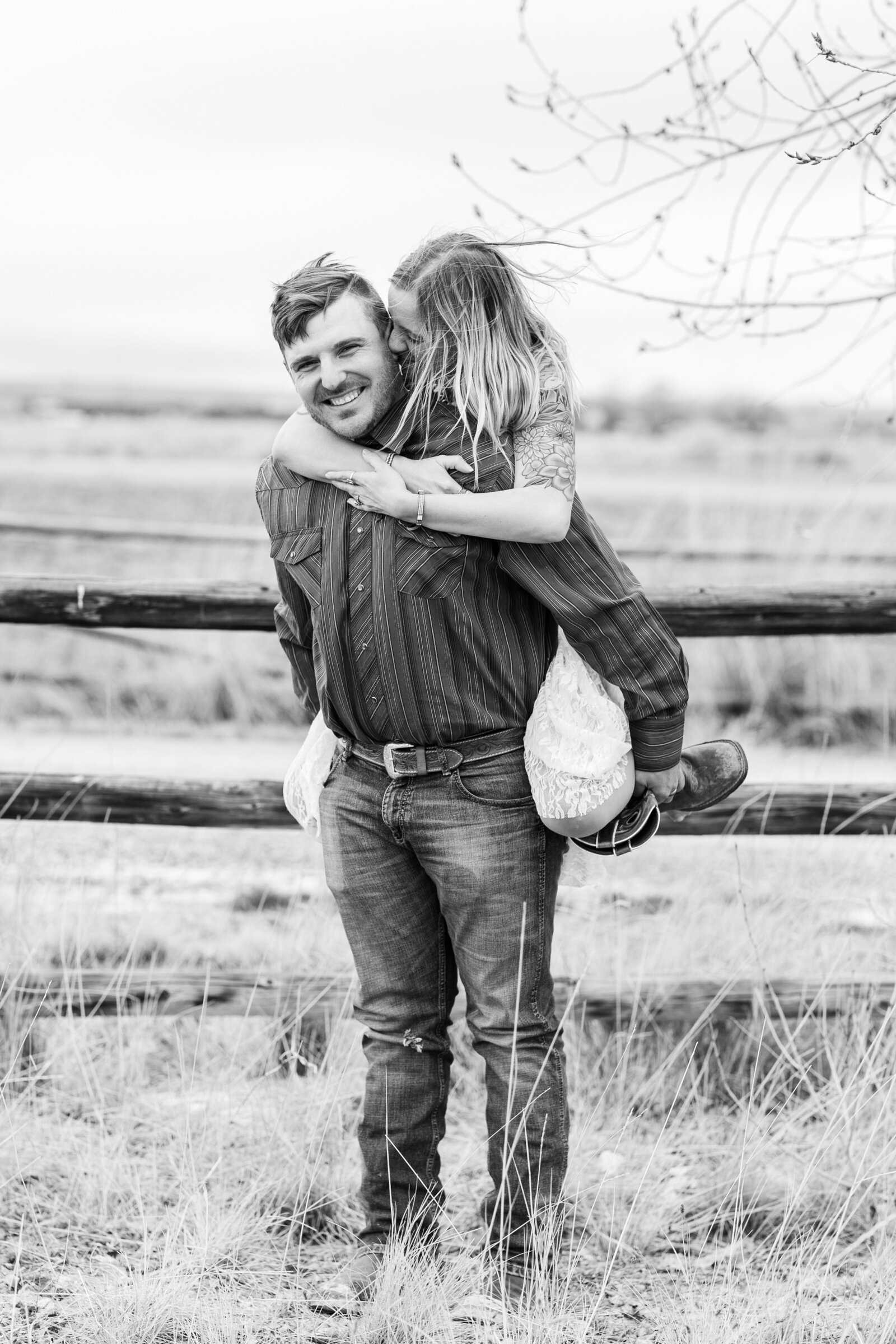 girl jumps on guys back and wraps arms around him for a fun engagement portrait, movement image