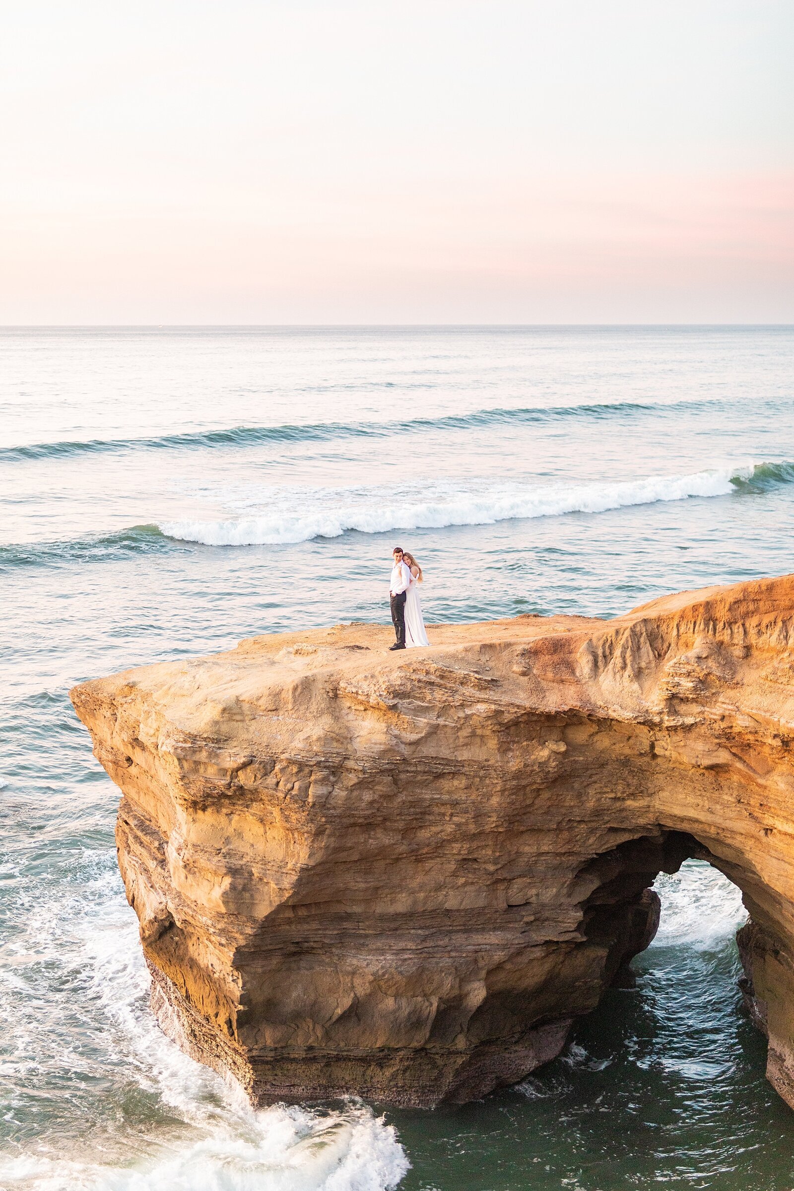 Couple cuddling on Sunset Cliffs in Point Loma.