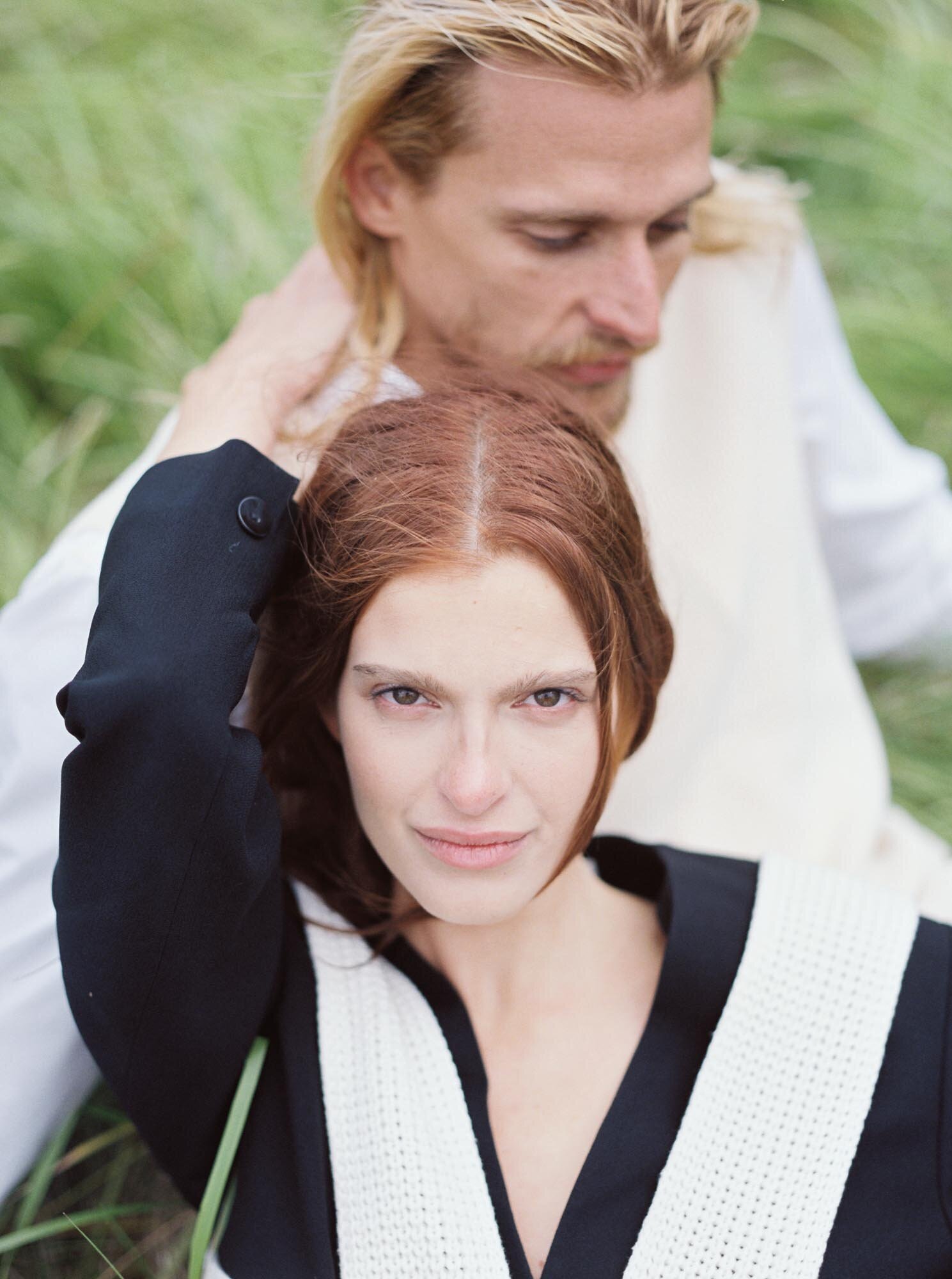 Couple lying  on a grass field in Iceland