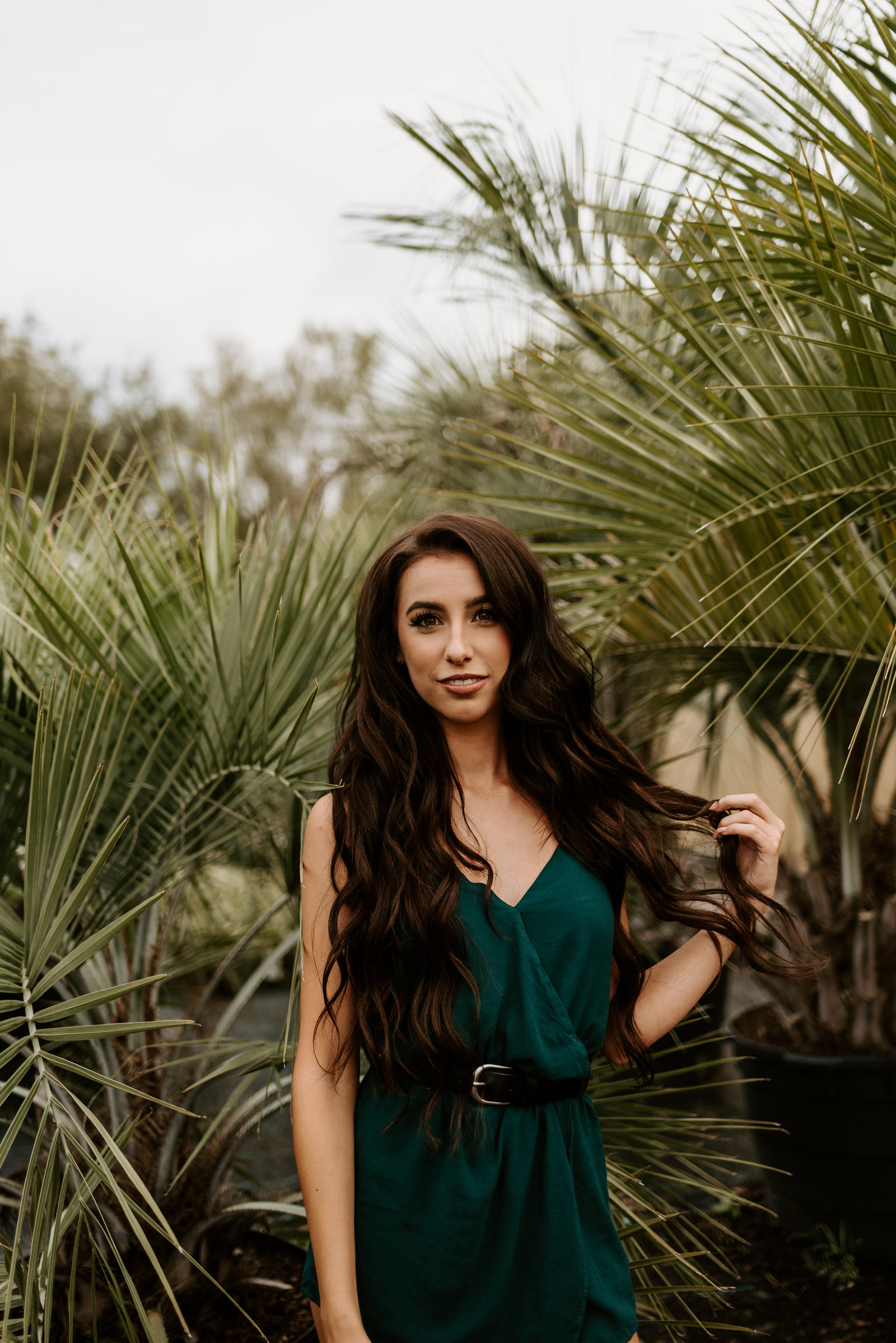 playing with hair next to plants