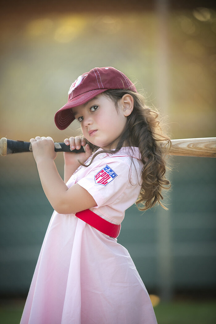 Little girl with Dallas child photographer at baseball photoshoot.