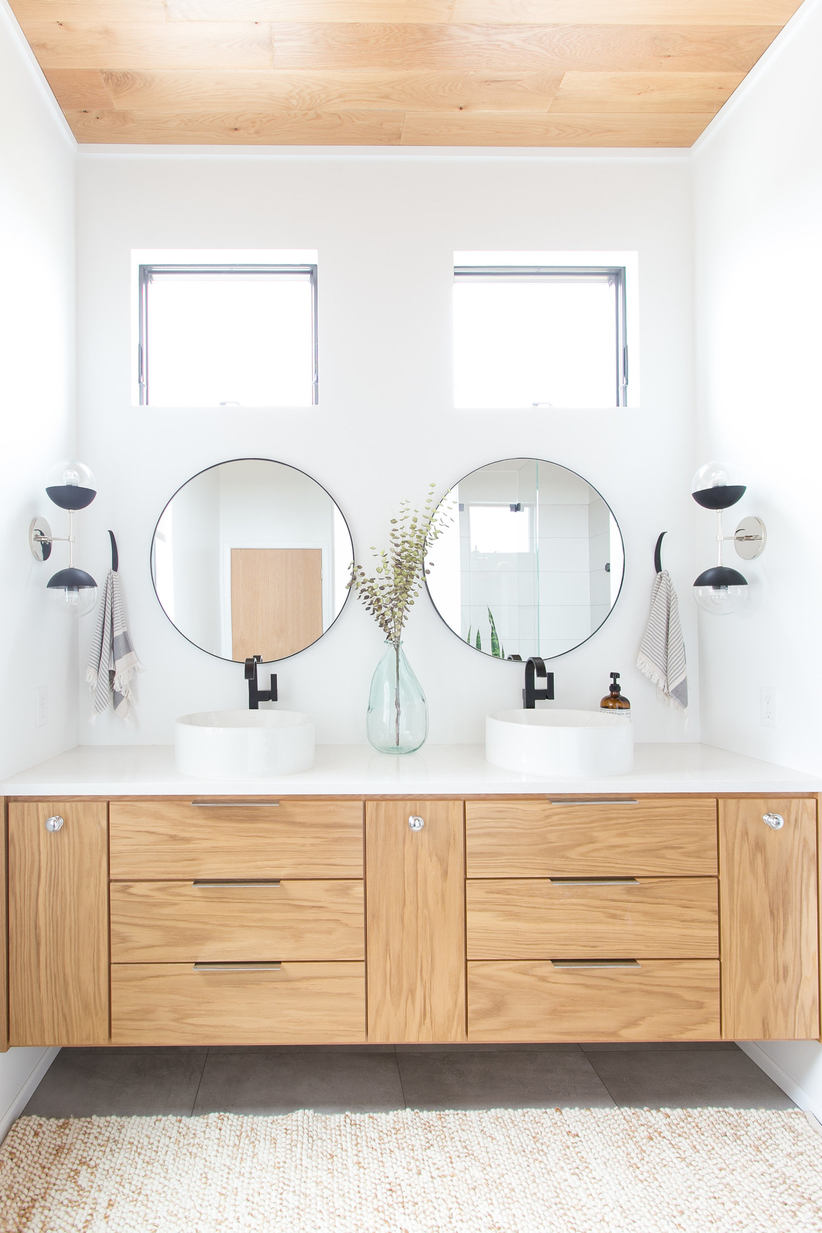 Modern master bathroom design with vessel sinks, floating shelves and vanity