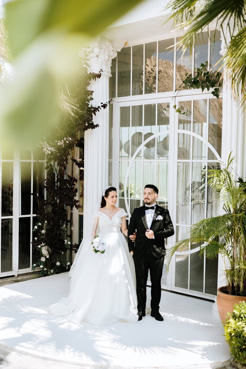 free-photo-of-portrait-of-a-bride-and-groom-standing-in-front-of-glass-ornate-doors