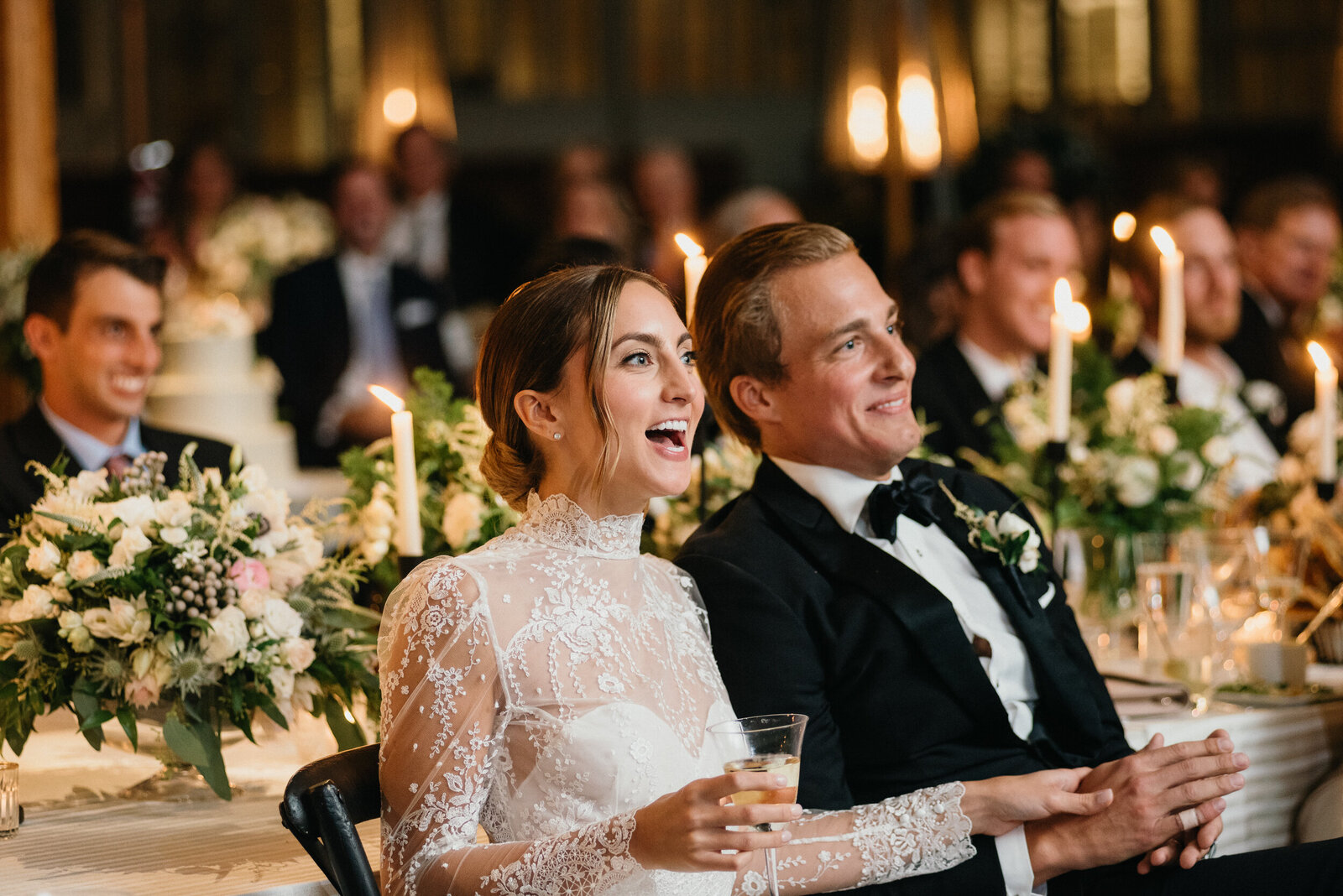 Bride and groom laughing during a toast at the outdoor reception near Philly.