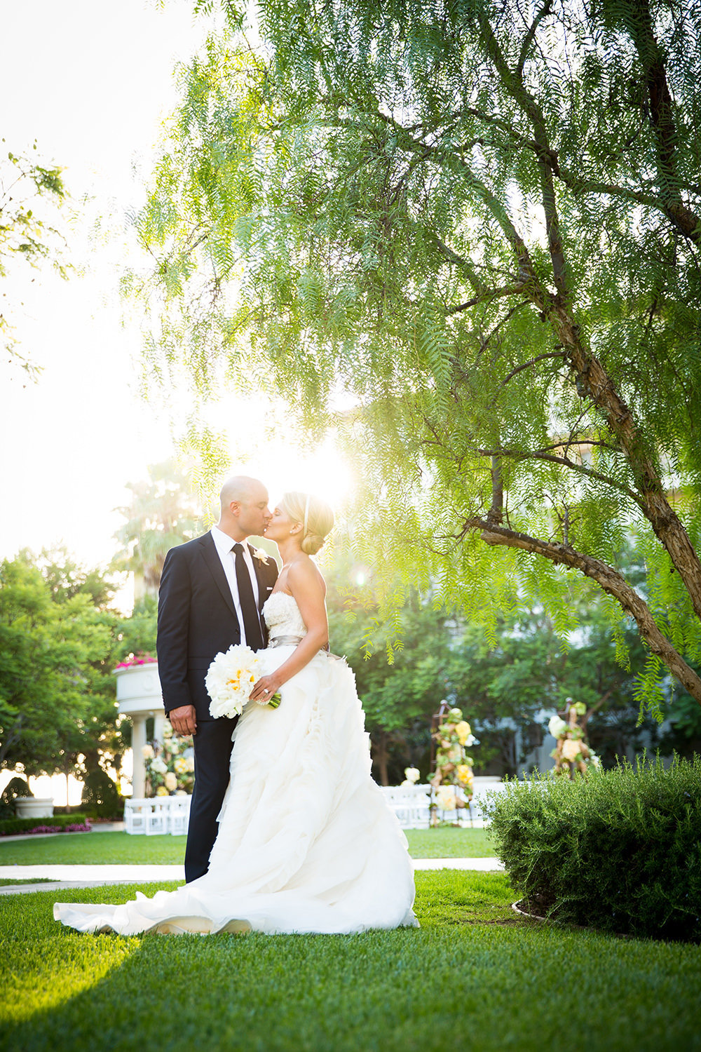 The sun shines through as our bride an groom sneak a kiss