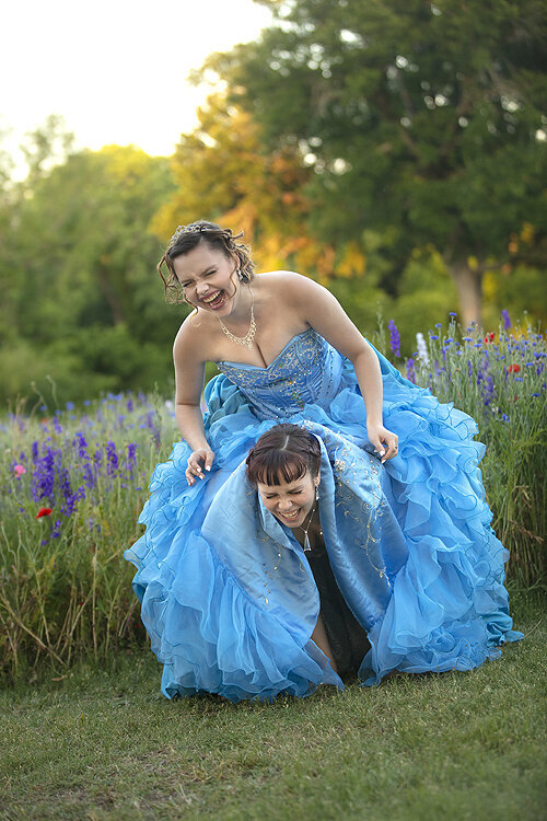 Girls in prom dress playing in flower field