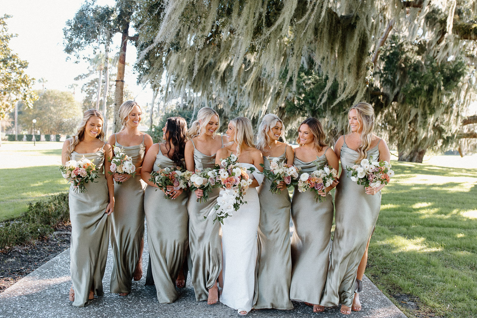 bride and her bridesmaids walking together with their bouquets at crane cottage