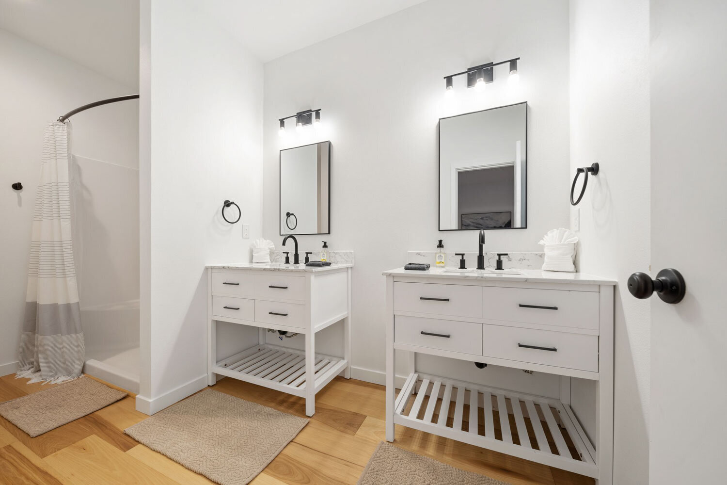 White double vanity bathroom with mirrors and bright lighting