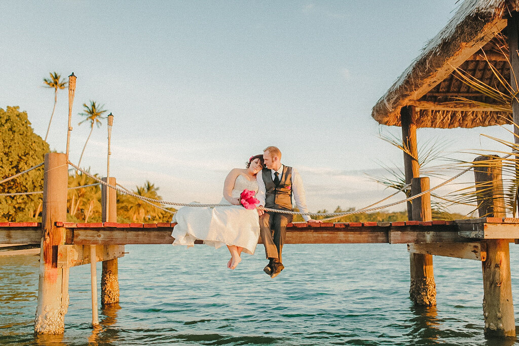 Couple sitting on a dock at golden hour