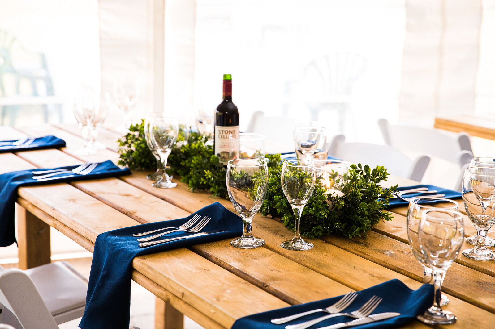 Harvest table setting with greenery and navy table linens..